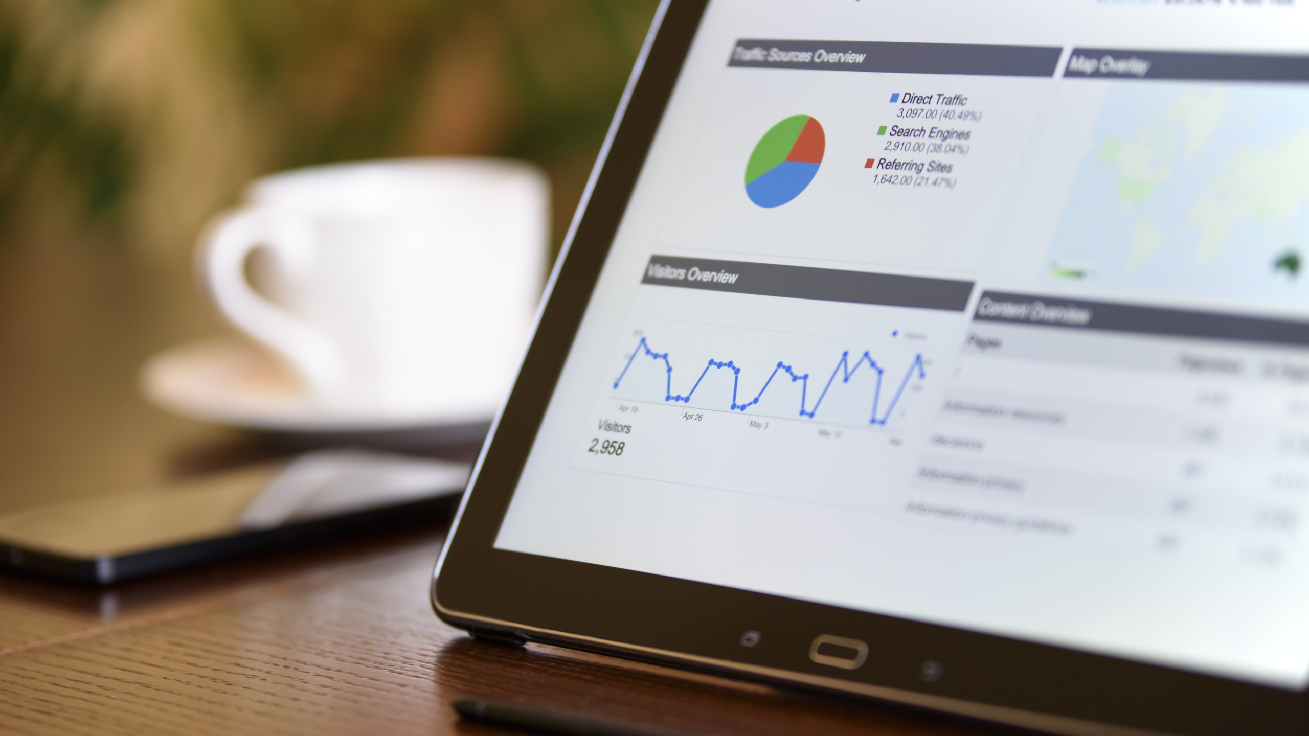 Picture of a tablet with generic analytics data. Data includes a pie chart, and a line chart.